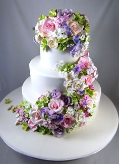 a three tiered wedding cake decorated with flowers