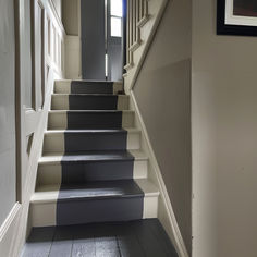 an empty hallway with stairs leading up to the door