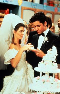 the bride and groom are cutting their wedding cake at the table in front of other people