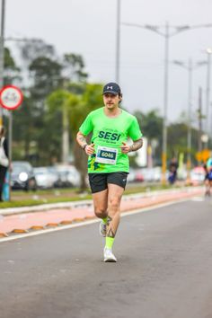 a man running down the street in a green shirt