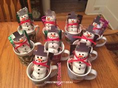 snowmen are wrapped in paper and sitting inside coffee cups