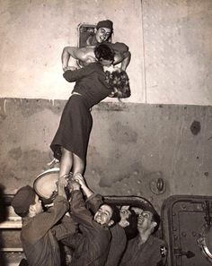 an old black and white photo with a woman being lifted by two men in the air