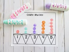 a counting game with crayons and markers on the paper next to it is an image of count and do