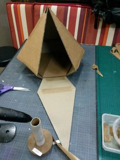 an open cardboard box sitting on top of a table next to scissors and other crafting supplies