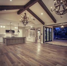 an open floor plan with wood floors and chandelier hanging from the ceiling,