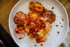 a white plate topped with pasta and meatballs