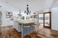 a large kitchen with an island in the middle and two stools next to it