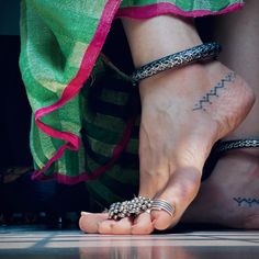 two people with tattoos on their feet and one holding onto the other's hand