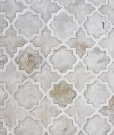 a white and gray tile with an intricate design on the outside, in different shades