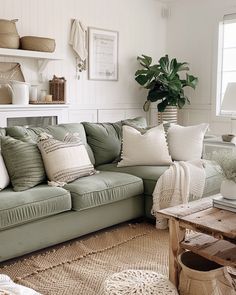 a living room filled with lots of furniture next to a potted plant on top of a table