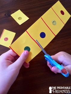 someone is cutting out some paper to make a piece of crafting material with scissors