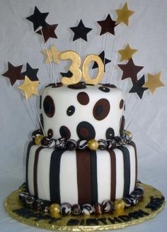 a white and black cake with gold stars on top