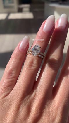 a woman's hand with a ring on it and a diamond in the middle