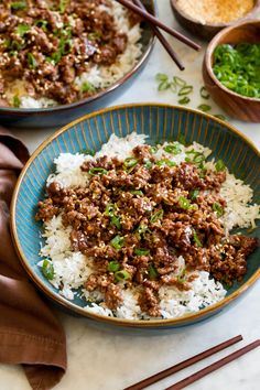 two bowls filled with rice and meat on top of a table