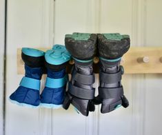 three pairs of snow boots are hanging on a coat rack in front of a door