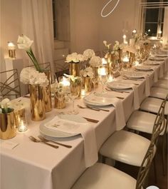 a long table is set up with white flowers and candles