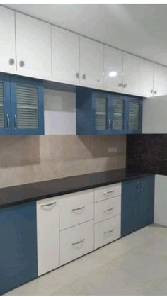 an empty kitchen with blue and white cabinets