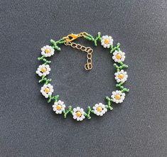 Pretty daisy design  encompassed in anklet  White and green glass seed beads golden yellow glass pearl bead centers finished with lobster clasp & extension chain and charm Length option available  Your order will be sent in an organza gift pouch shipping Free delivery on all uk orders International is by Airmail,please see listings for destination/rate I am not a big business but a one woman operation. I pride myself with attention to detail and strive to offer a swift and efficient service. If anything is not to your complete satisfaction I would appreciate to be given the opportunity to put it right BEFORE feedback is left. Any problems: Please send me a message before opening a case as most problems can be quickly & easily resolved . Dainty Beaded Jewelry For Summer, Summer Gold Jewelry With Tiny Beads, Gold Jewelry With Tiny Beads For Summer, Dainty Beach Jewelry For Spring, Dainty Spring Beach Jewelry, Green Dangle Jewelry For Spring, Trendy Spring Jewelry With Tiny Beads, Gold Jewelry With Colorful Beads For Summer, Dainty Yellow Jewelry With Tiny Beads