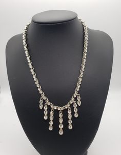 "A lovely formal and elegant piece 1950's and 1960's  jewelry which was meant to highlight femininity.  The shimmering clear cubic zirconia is  meant to reflect any light in the room and are  beautifully laid out in a  graduating tear drop design.  The rhinestones are all set tight in their settings. Necklace marked 925 on clasp. Please see pictures for condition and description. The necklace measures 15\" inches in the chain with a 3\" inch extension. Original, one-of-a-kind vintage piece from Simple Bridal Necklace, Formal Necklace, Cocktail Necklace, Waterfall Necklace, 1960s Jewelry, Dog Brooch, Cubic Zirconia Necklace, Drop Design, Art Deco Necklace