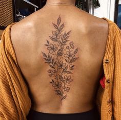 the back of a woman's body with flowers on her upper and lower back