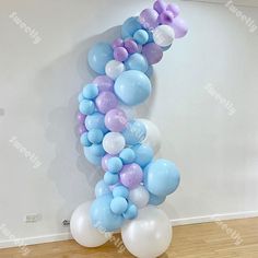 the balloon arch is decorated with pastel blue, lavender and white balloons