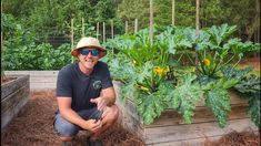 a man kneeling down in front of some plants