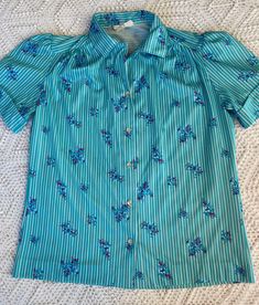 Vintage 70s/80s blue polyester short sleeve blouse. Size. S Measurements: 20x15x8.5' arms. This is a vintage blouse with button closer  in the front.  NO stains or holes that I can find. . I do have other items in the shop that would look great with this vintage piece, so check them out.  ALL sales are final so please email me with any questions you have before purchasing.  I ship USPS either priority box, recycled box or large mailer bag. Polyester Blouse, Vintage Blouse, Historical Clothing, Blouse Vintage, Floral Shirt, Short Sleeve Blouse, Vintage 70s, Shirt Sleeves, Blue Floral