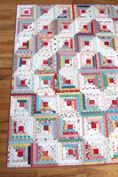 a quilt is laying on the floor in front of a wooden floor with wood floors