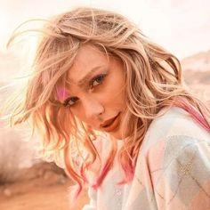 a woman with blonde hair standing in the desert