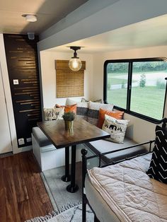 a living area with couches, table and windows