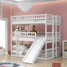 a white bunk bed with a slide in front of it and a rug on the floor