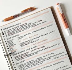 a notebook with some writing on it next to a pen and two markers in front of it