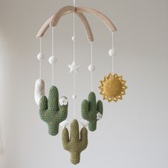 a crocheted cactus mobile hanging from a ceiling