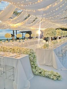 an image of a table set up for a wedding reception with flowers and candles on it