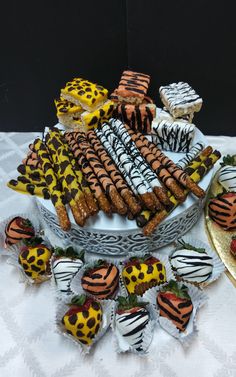 a table topped with lots of different types of cookies and strawberries on top of each other