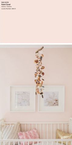 a baby's crib with pink walls and pictures on the wall above it