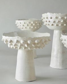 three white vases sitting next to each other