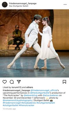 two ballerinas are dancing on stage with one holding the other's hand