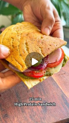 a person holding a sandwich in their hand with the words, 15 min high protein sandwich