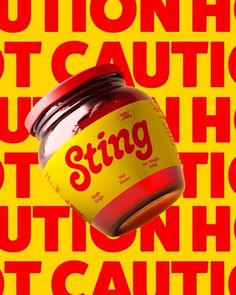 a jar filled with red liquid sitting on top of a yellow and red sign that says caution