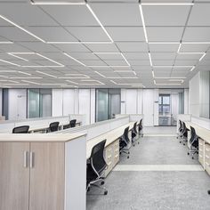 an empty office cubicle with desks and chairs