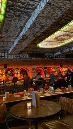 the inside of a restaurant with tables, chairs and stained glass windows on the ceiling