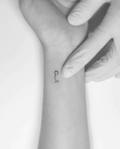 a woman's wrist with a small tattoo on the left side of her arm