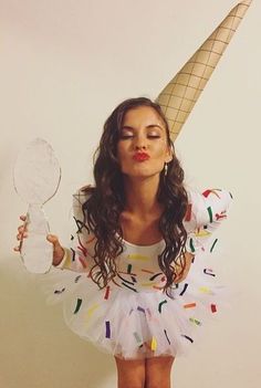 a woman in a white dress holding a mirror and an ice cream cone