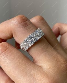 a woman's hand with a wedding band on it, and the ring is made out of white gold