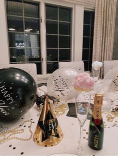 a party table with champagne, balloons and confetti