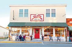 people sitting outside the front of a country store