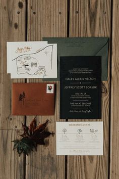 the wedding stationery is laid out on top of wood planks, including an envelope and