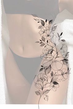 a woman's stomach with flowers and leaves on the side, in black and white