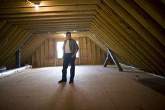 a man standing in the middle of an attic